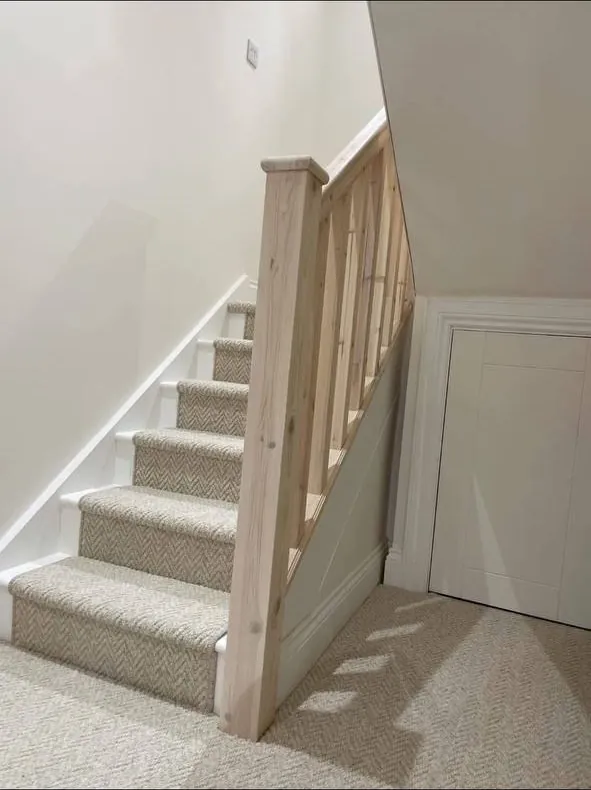 Staircase with timber spindles and panelled under-stair cupboard